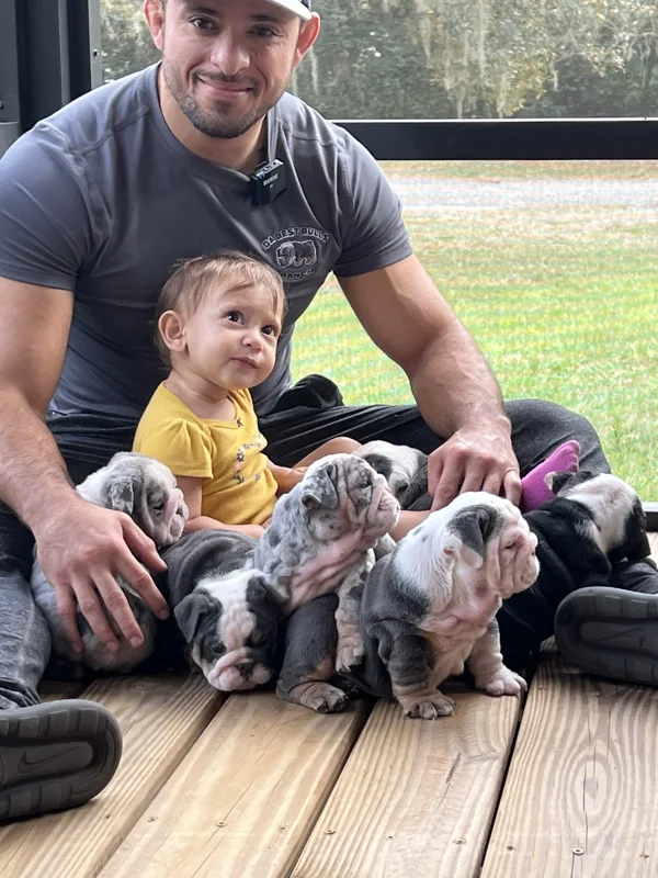 Jason Soares with his daughter and a litter of puppies