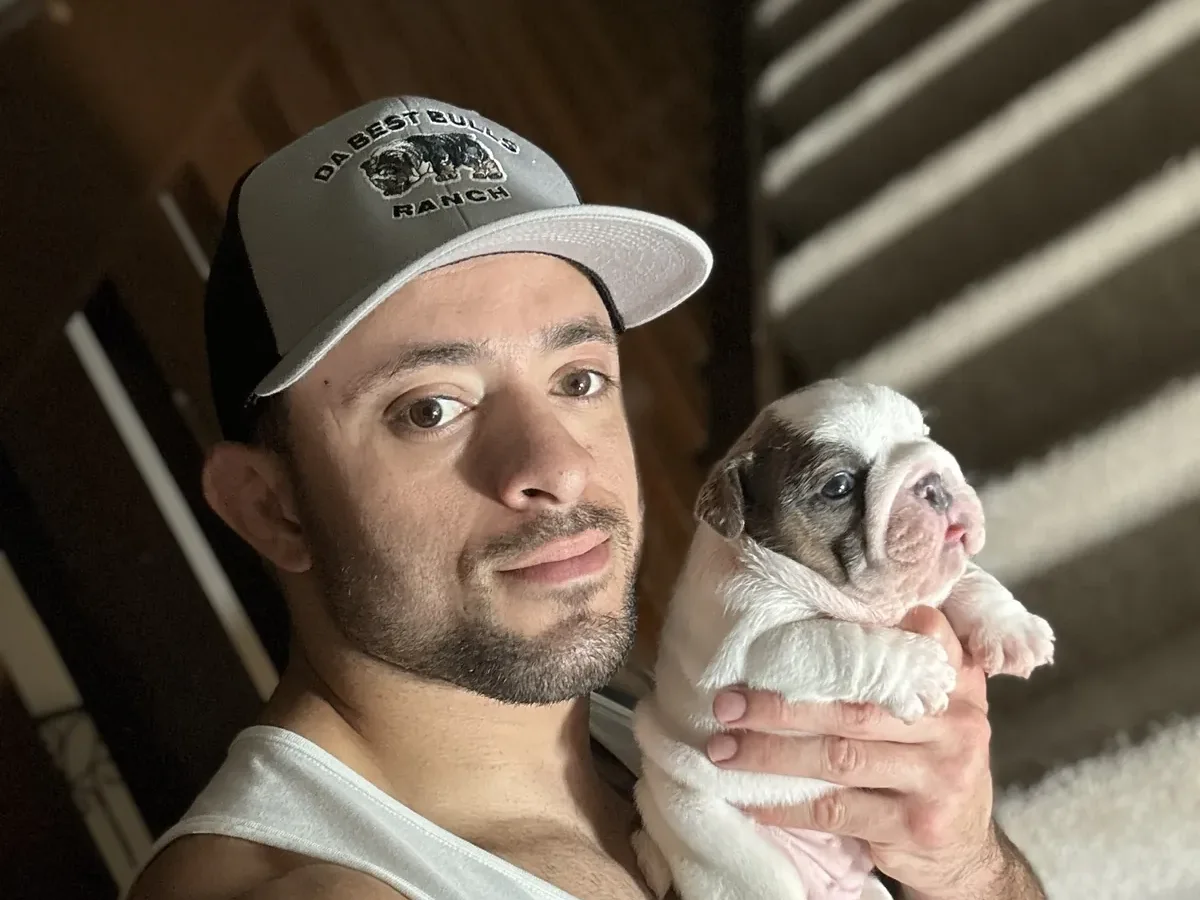 Jason Soares holding a young English bulldog puppy